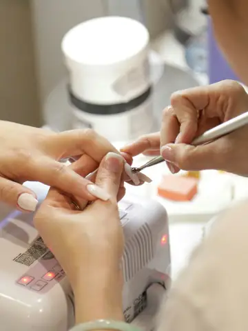 A manicurist shaping a client's nails